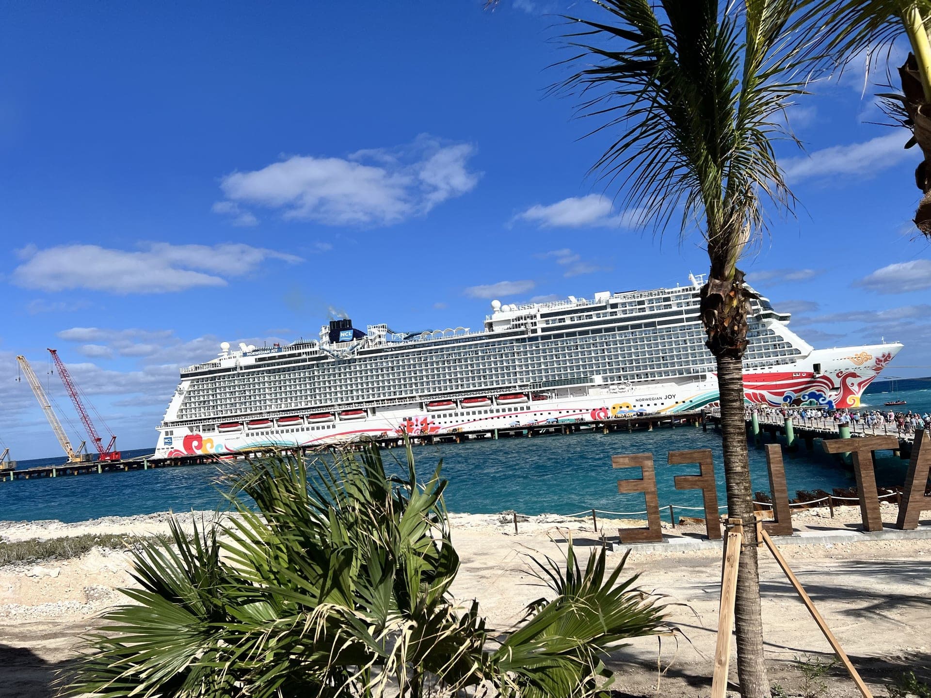 Norwegian Joy cruise ship docked at a tropical Caribbean port